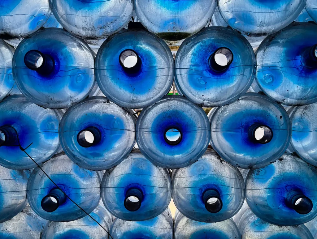 Mexico City. Empty blue water jugs stacked.