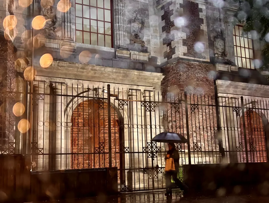 Mexico City. A person walking on the rainy streets with an umbrella in Mexico City.